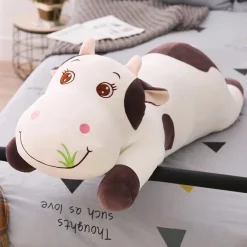 Peluche vache coloré qui broute de l'herbe